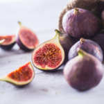 A few figs freely lying on old wooden table.