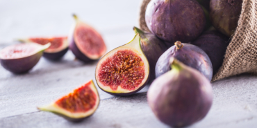 A few figs freely lying on old wooden table.