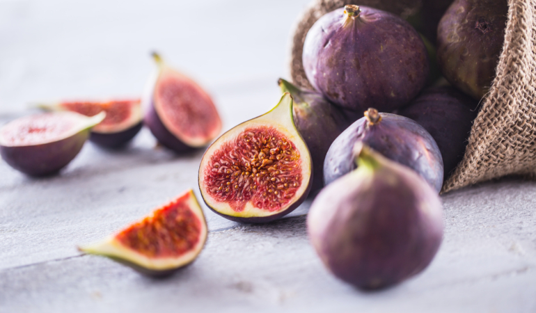 A few figs freely lying on old wooden table.