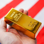 The gold bar in man's hand on the national flag of USA background. Gold Reserve concept.